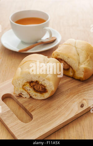 Tagliare il pane dolce con latte caldo tè su uno sfondo di legno Foto Stock