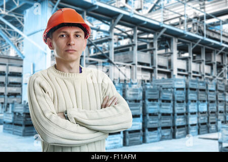 Workman nella grande sala di storage con scatole di metallo in fabbrica Foto Stock