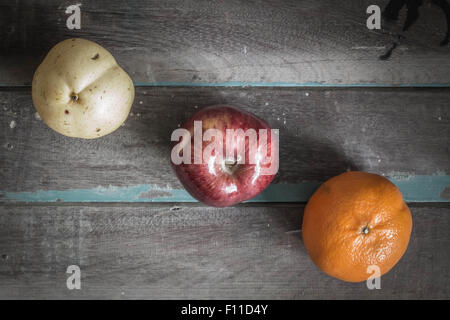 Tre tipi di frutta disposta sul vecchio pavimento in legno. Foto Stock