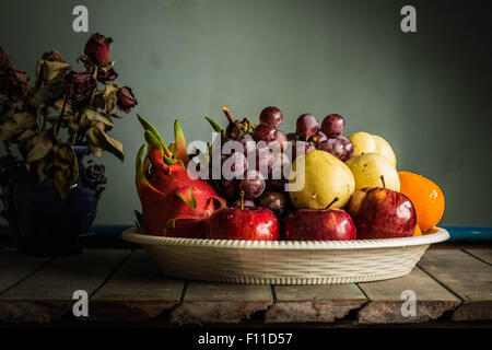Molti frutti in un vassoio su un tavolo di legno Foto Stock