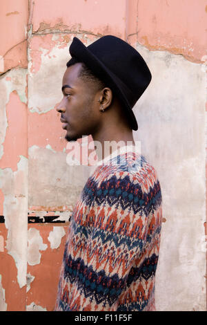 Profilo di uomo nero in piedi da edificio fatiscente Foto Stock