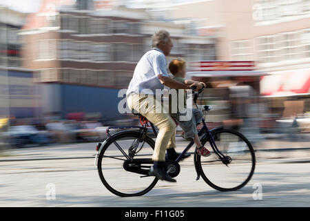 Vista offuscata del padre e figlio di ciclismo su strada di città Foto Stock