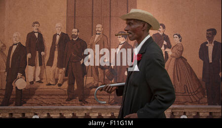 Uomo ispanico oltrepassando murale, Havana, Cuba Foto Stock