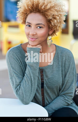 Donna nera mento di appoggio in mano all'aperto Foto Stock