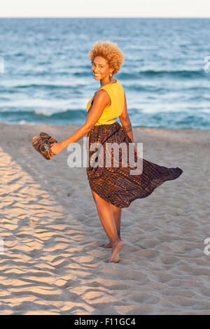 Nero donna sandali portante sulla spiaggia Foto Stock