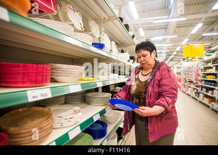 La donna caucasica shopping per piatti in negozio Foto Stock