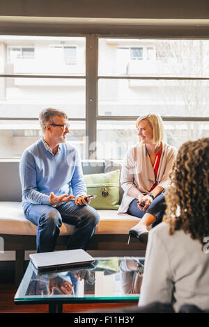La gente di affari di parlare nella lobby di office Foto Stock