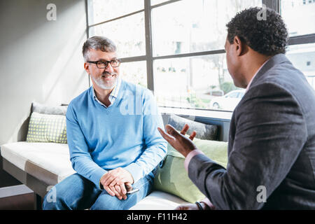 Imprenditori parlando nella lobby di office Foto Stock