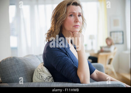 Interessato Caucasian donna seduta sul divano Foto Stock