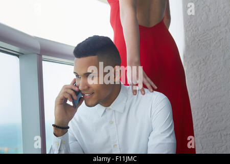 Imprenditore parlando al cellulare nei pressi di ragazza Foto Stock