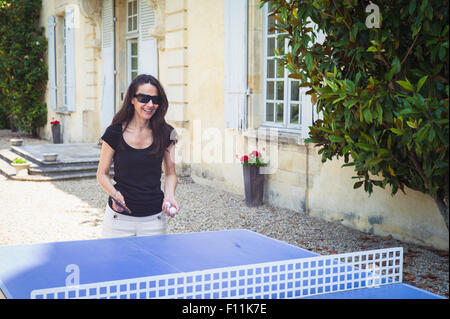 La donna caucasica giocando a ping-pong in cantiere Foto Stock