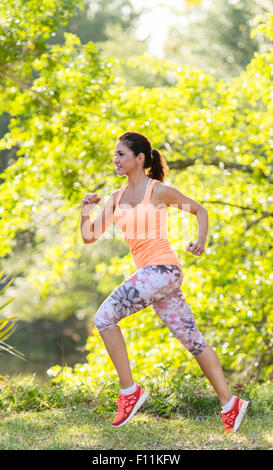 Donna ispanica a fare jogging nel parco Foto Stock