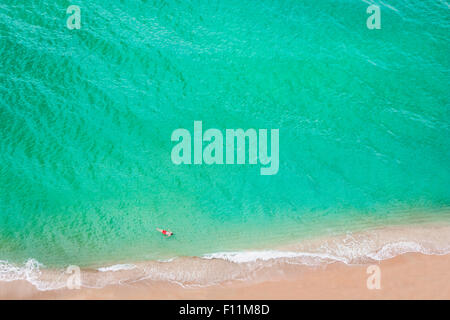 Vista aerea del uomo caucasico nuoto in mare sulla spiaggia Foto Stock