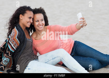 Le donne che prendono selfies sulla spiaggia Foto Stock