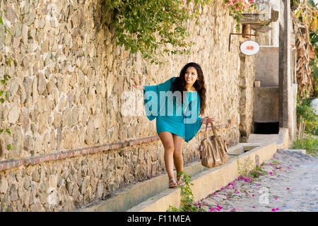 Donna ispanica bilanciamento sulla parete di pietra Foto Stock