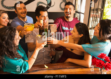 Ispanico amici bevendo un drink presso il bar Foto Stock