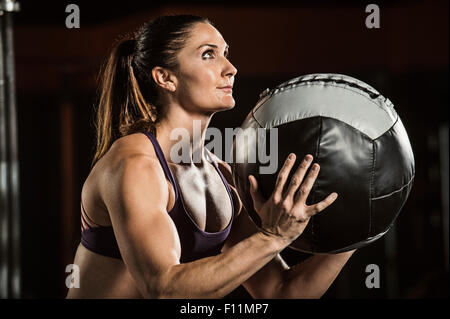 Atleta caucasica resistenza sollevamento palla in palestra Foto Stock