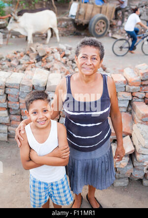 Nonna ispanica e nipote sorridente in macerie Foto Stock