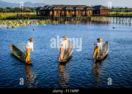 Asian pescatori pesca in canoa sul fiume Foto Stock