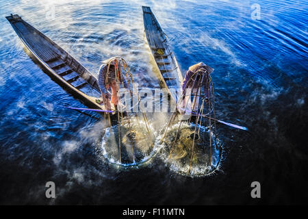 Angolo di alta vista di pescatori asiatici tramite rete da pesca in canoa sul fiume Foto Stock