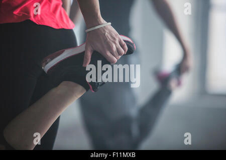 Gli atleti lo stiramento delle gambe in palestra Foto Stock