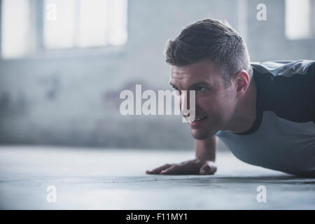 Atleta caucasica facendo push-up sul pavimento Foto Stock