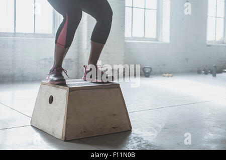 Atleta salto sulla piattaforma in palestra Foto Stock