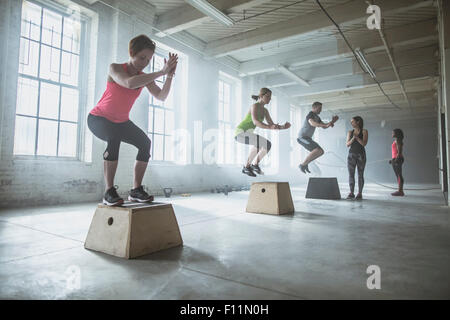 Gli atleti saltando su piattaforme in palestra Foto Stock