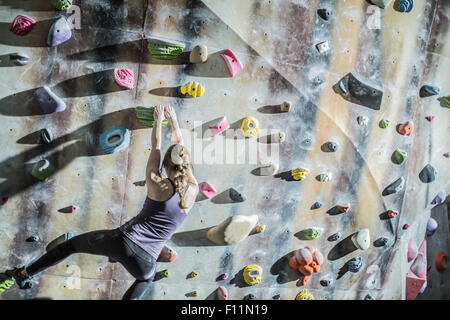 Atleta di arrampicata parete di roccia in palestra Foto Stock