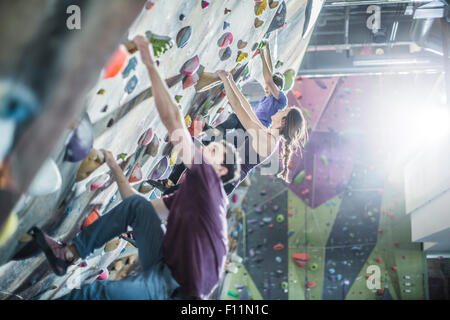 Gli atleti di arrampicata parete di roccia in palestra Foto Stock