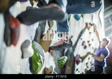 Gli atleti di arrampicata parete di roccia in palestra Foto Stock
