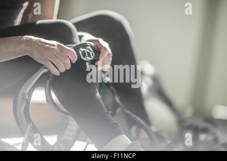 Atleta di fissaggio cablaggio di arrampicata in palestra Foto Stock