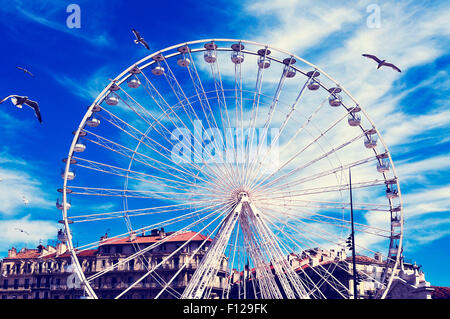 Gabbiani e una ruota panoramica Ferris al porto vecchio di Marsiglia, Francia, con un effetto di filtro Foto Stock