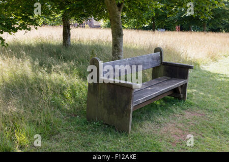 In legno antico sedile unico in un parco Foto Stock