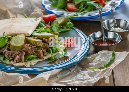 Tirato agnello con rucola fresca insalata e pane pitta Foto Stock