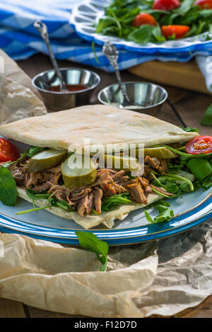 Tirato agnello con rucola fresca insalata e pane pitta Foto Stock