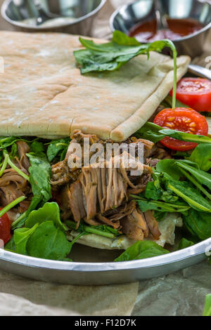 Tirato agnello con rucola fresca insalata e pane pitta Foto Stock