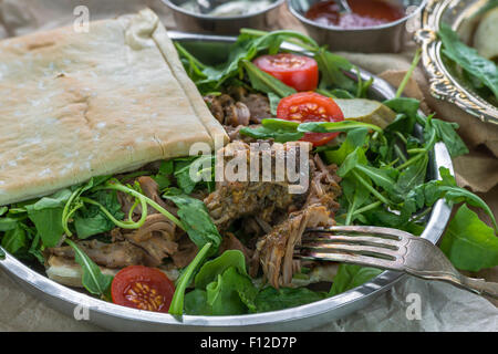 Tirato agnello con rucola fresca insalata e pane pitta Foto Stock