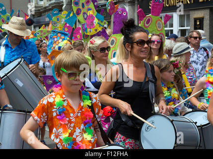 Famiglie locali marciare insieme in parata durante l annuale Giornata Mazey celebrazioni a Penzance, Cornwall, Regno Unito Foto Stock