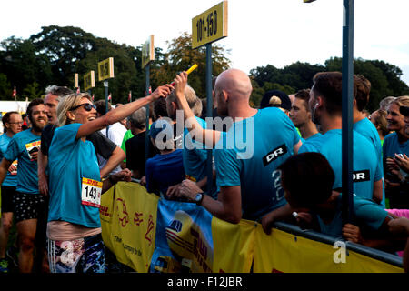 Copenhagen, Danimarca, Agosto 25th, 2015. Runner (L) dalla nazionale danese TV e Radio, DR, che partecipano al relè di DHL Rally di Copenaghen offre il testimone alla prossima nel loro team di 5. Credito: OJPHOTOS/Alamy Live News Foto Stock