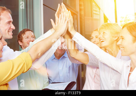 Start-up team aziendale dando alta cinque con le loro mani in estate Foto Stock