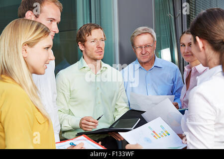 La gente di affari di riunione del team esterni e a parlare con ciascun altro Foto Stock