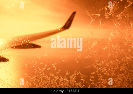La vista di smerigliato finestra aereo al tramonto Foto Stock