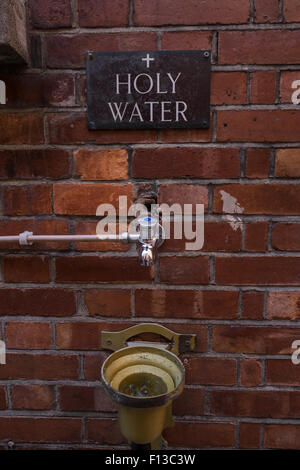 L'acqua santa toccare uscita sulla parete a St Teresas Chiesa di Clarendon Street, Dublin. Foto Stock