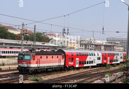 Locomotiva elettrica OBB in livrea rosso in corrispondenza della parte anteriore del double deck città treno navetta lasciando alla stazione Westbahnhof, Vienna, Austria Foto Stock