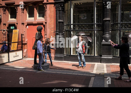 I turisti che posano per una foto con la dimensione di vita statua in bronzo di Phil Lynnot su Harry Street a Dublino centro città di Dublino in Irlanda Foto Stock