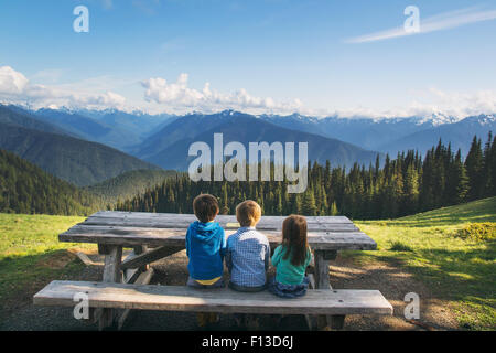 Vista posteriore di tre bambini seduti su una panca che guarda vista, Stati Uniti Foto Stock