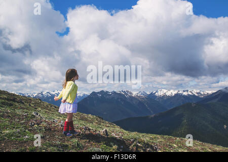 Bambina permanente sulla montagna con le braccia aperte Foto Stock