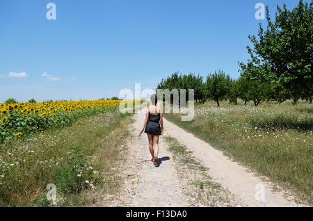 Vista posteriore di una giovane donna che cammina verso il basso il percorso Foto Stock
