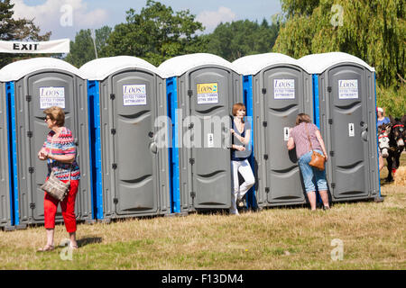 Fila di servizi igienici portatili al Salone annuale della Società agricola di Ellingham & Ringwood a Hampshire, Regno Unito nel mese di agosto Foto Stock